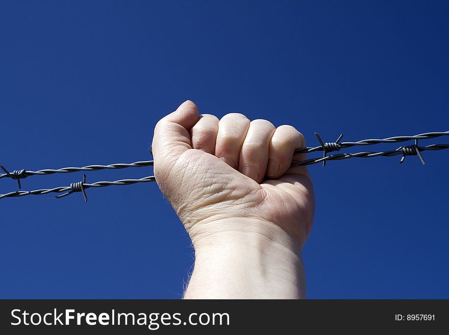 Fist holding round a barbed wire