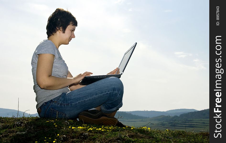 Young casual woman working on laptop