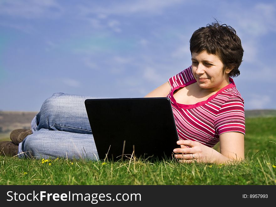 Young casual woman working on laptop