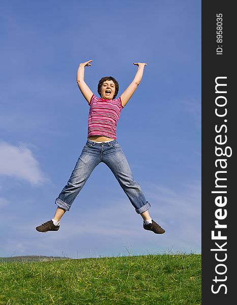 Young happy woman jumping high against blue sky