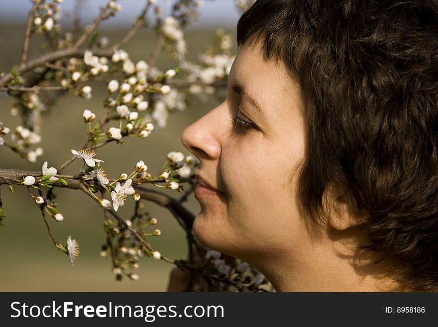 Beautiful young woman amongst spring blossom