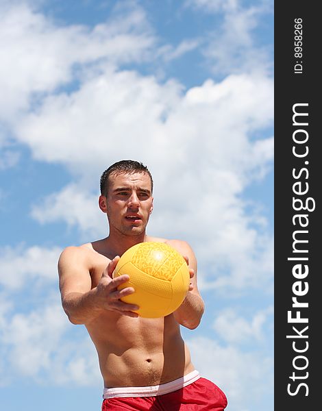 Athletic guy playing volley-ball on the beach. Athletic guy playing volley-ball on the beach