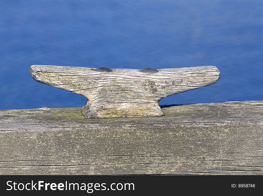 Wooden cleat with the blue water in tha background