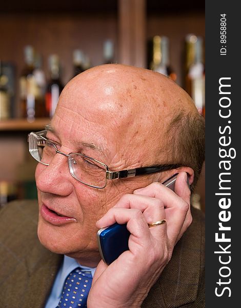 En elderly man communication with a mobile phone