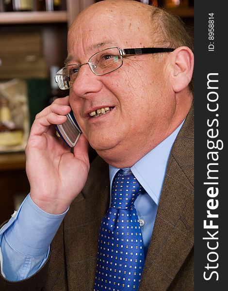 En elderly man communication with a mobile phone
