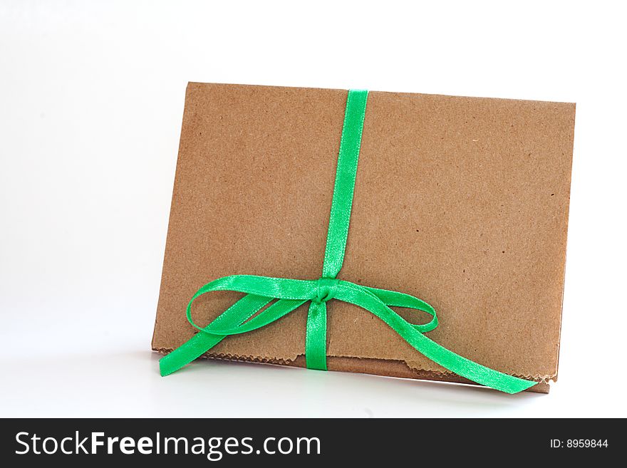 Concept for earth day recycled brown paper bag wrapped in green ribbon