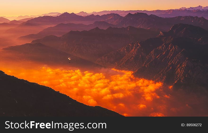 Scenic View of Mountains Against Dramatic Sky at Sunset