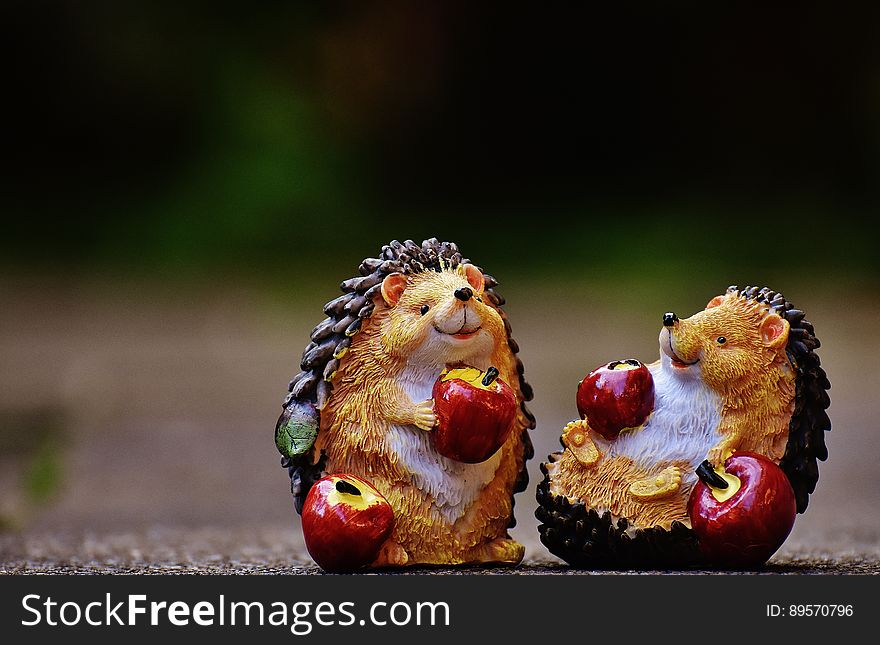 Close up of figurines of hedgehogs eating red apples. Close up of figurines of hedgehogs eating red apples.