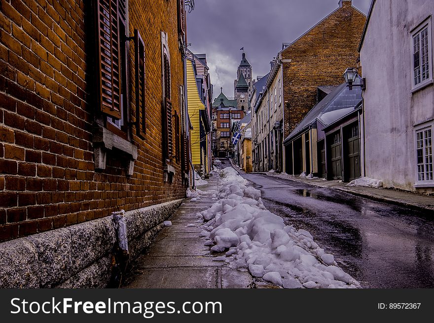 An alleyway in the city in the winter with snow collected on the sidewalk. An alleyway in the city in the winter with snow collected on the sidewalk.