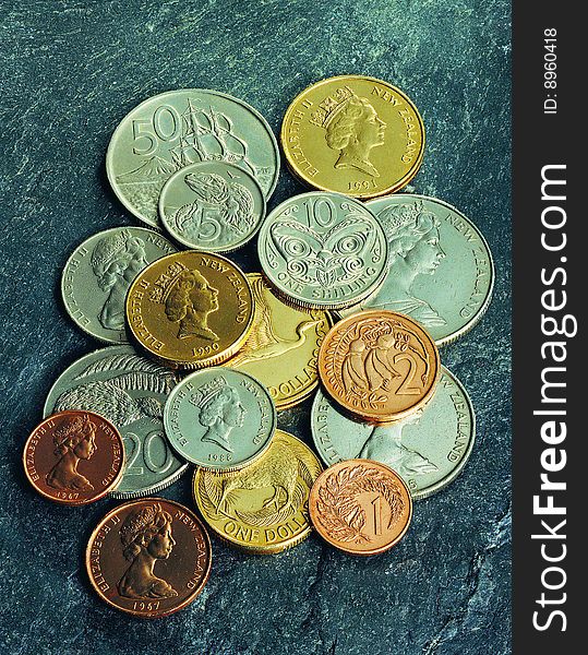 A heap of colorful coins on stone background