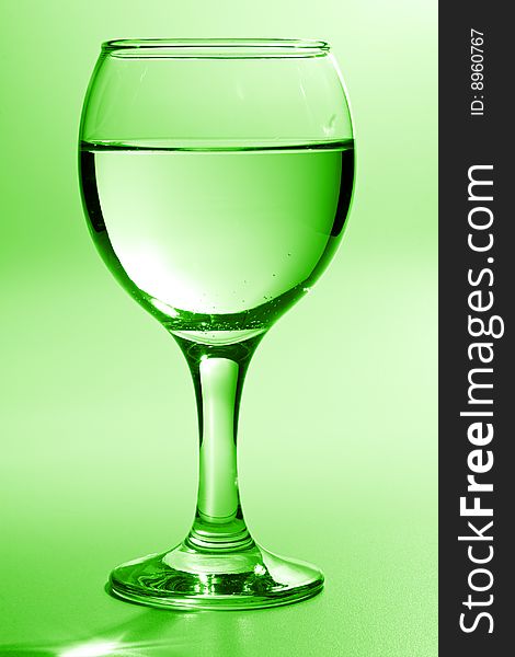 Beautiful wine glass with water toning in green. Beautiful wine glass with water toning in green