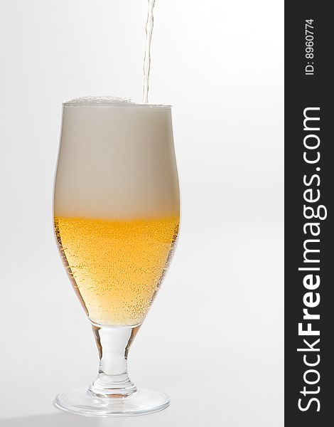 Glass with poured beer isolated on white background