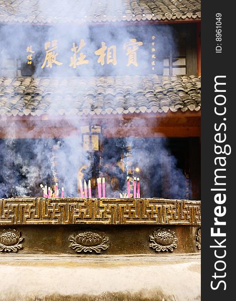 A picture of hall of buddhism temple in sichuan province of china, with diffusive smoke of candles and joss sticks. A picture of hall of buddhism temple in sichuan province of china, with diffusive smoke of candles and joss sticks