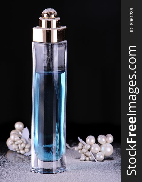 Tall perfume bottle with blue liquid in studio lighting