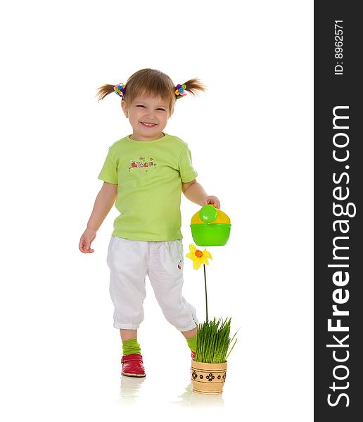 Cute little girl watering the flower. Studio shot