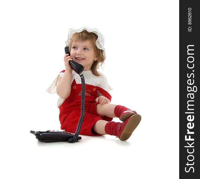 Little girl speaks on the phone. Studio shot