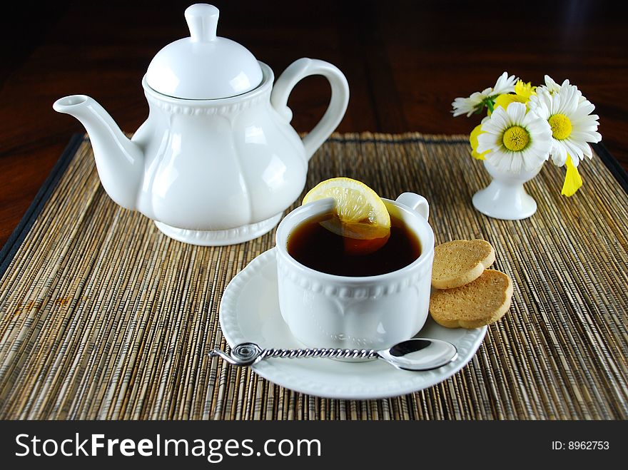 A fresh hot cup of tea with lemon and cookies