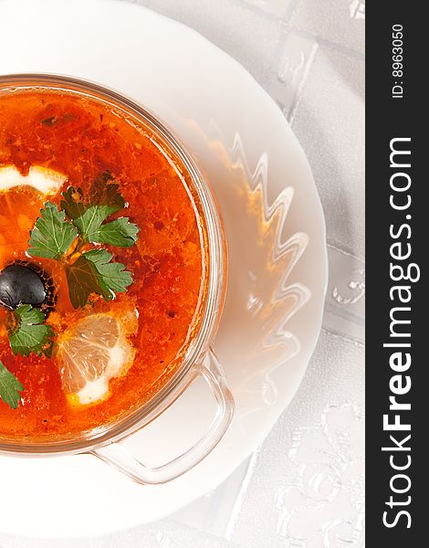 Delicious red soup in a glass bowl over white