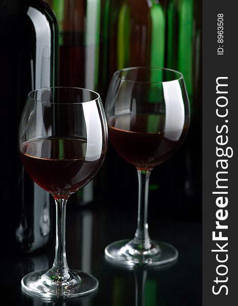 Bottles and glasses of excellent wine on a dark background. Bottles and glasses of excellent wine on a dark background