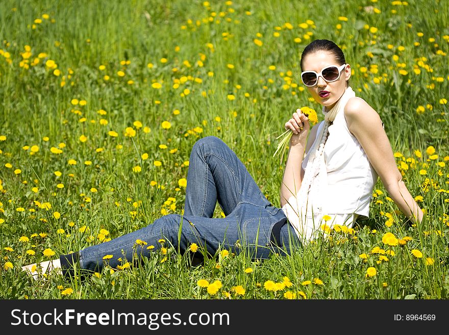 Young Woman In Nature Smelling A Flower