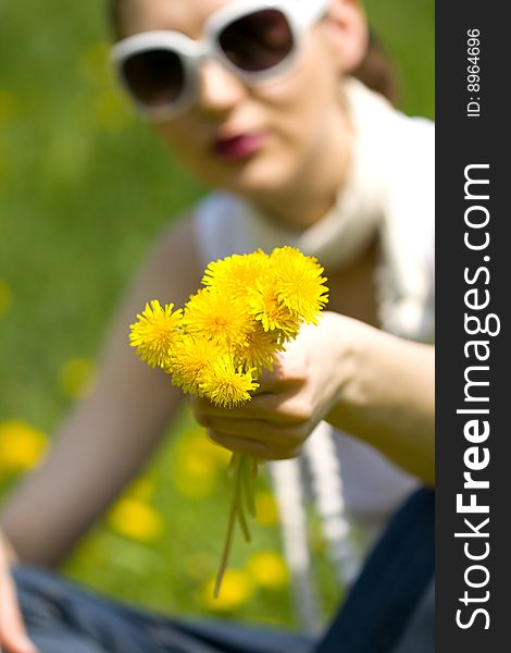 Young woman in nature offering flowers