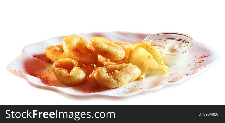 Onion rings with sauce and lemon