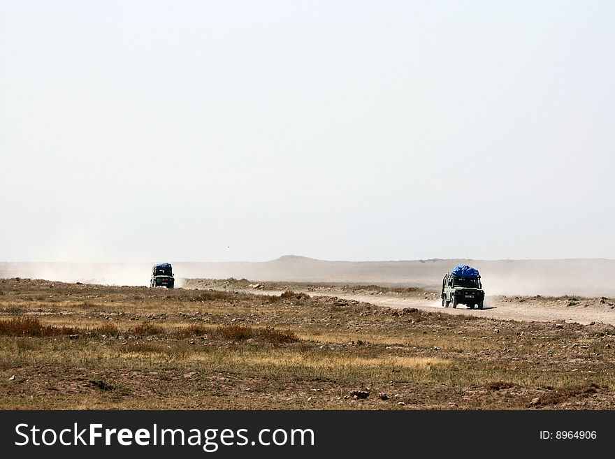 Safari 4WD cars on a dusty road from Ngorongoro crater to Serengeti National Park, Tanzania