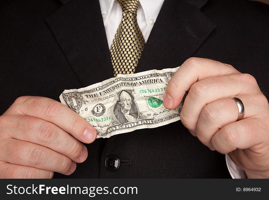 Businessman in a Suit and Tie Holding Wrinkled United States Dollar Bill. Businessman in a Suit and Tie Holding Wrinkled United States Dollar Bill.
