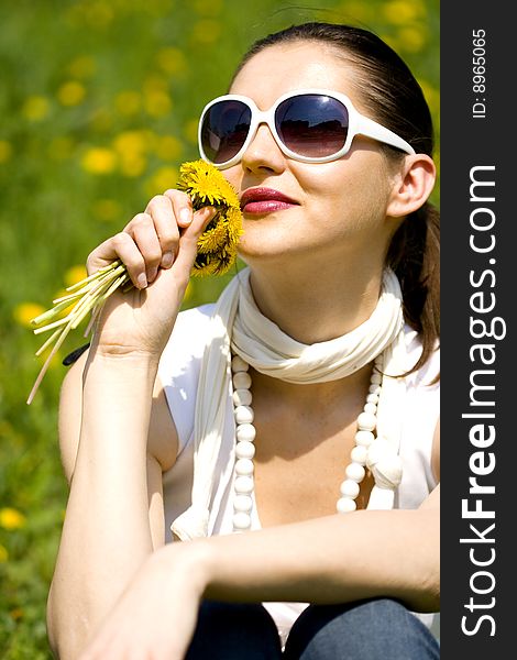 Young Woman In Nature Smelling  Flowers