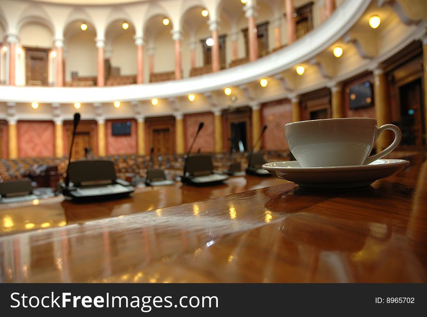 Cup of coffee in empty conference room, coffee break