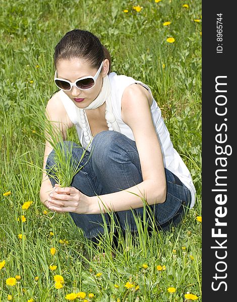 Young woman in nature holding grass