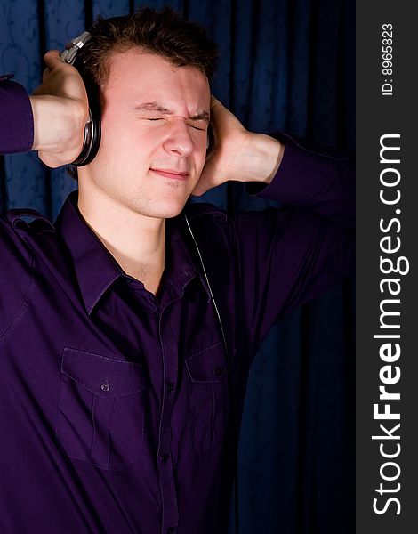 Close up portrait of young man with headphones indoors. Close up portrait of young man with headphones indoors