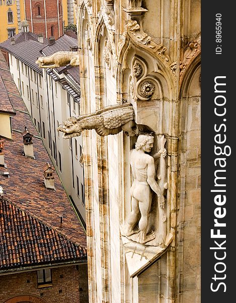 Detail of filagree stone carving, gargoyles, and statues on the exterior of the Milan Cathedral in Italy. Detail of filagree stone carving, gargoyles, and statues on the exterior of the Milan Cathedral in Italy