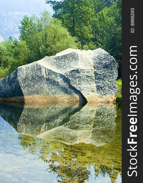 Granite boulder reflected in Mirror Lake at Yosemite National Park. Granite boulder reflected in Mirror Lake at Yosemite National Park