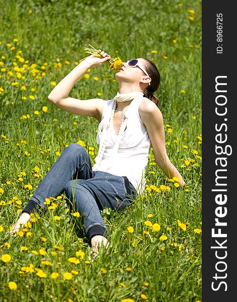 Young woman in nature smelling flowers