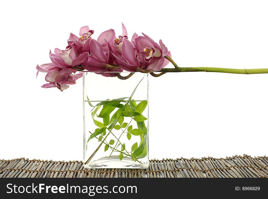 Bowl of fresh leaf with pink orchid on bamboo mat. Bowl of fresh leaf with pink orchid on bamboo mat