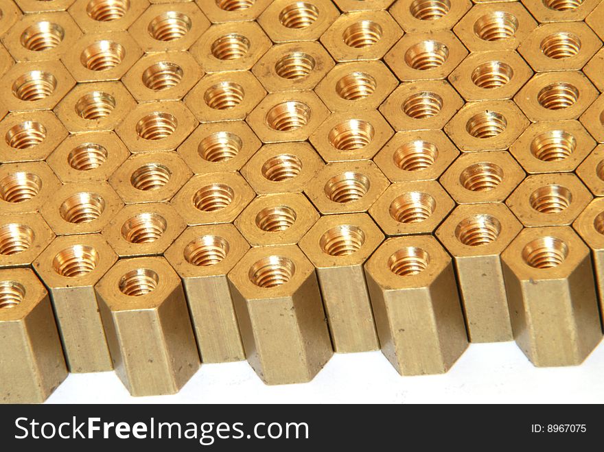 Background made of golden hexadonal screw-nuts. Background made of golden hexadonal screw-nuts