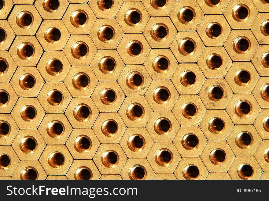 Background made of golden hexadonal screw-nuts. Background made of golden hexadonal screw-nuts