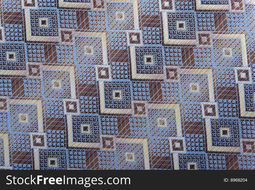 Textile background with blue, brown and golden shapes