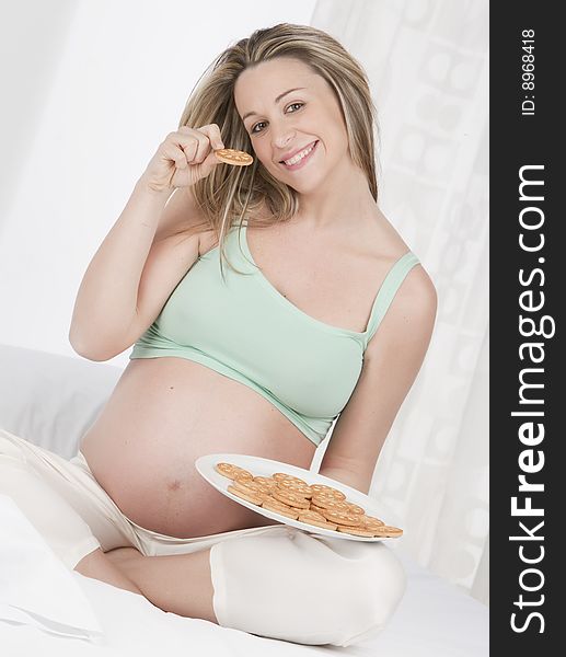 Pregnant woman in bed eating