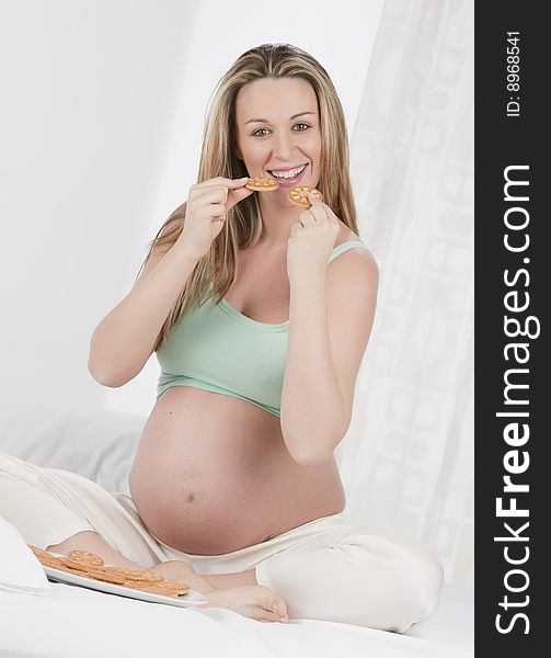 Pregnant woman in bed eating