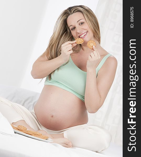 Pregnant woman in bed eating