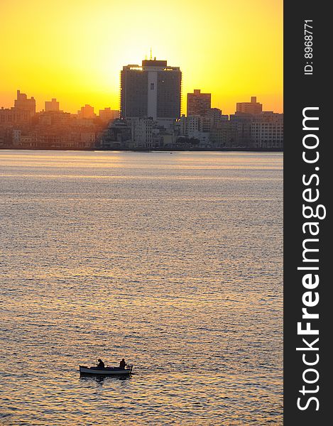 A view of havana skyline at sunset with fishing boat on the front