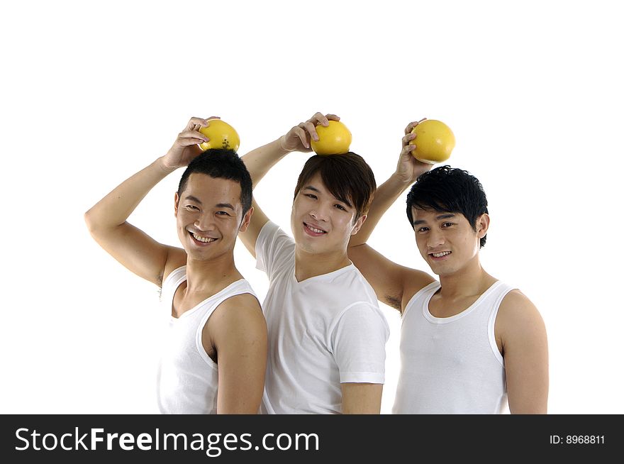 Three young man holding grapefruit on his head. Three young man holding grapefruit on his head