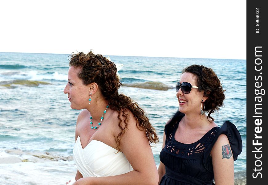 Two sisters enjoying a wedding at the beach at a resort in mexico. Two sisters enjoying a wedding at the beach at a resort in mexico.
