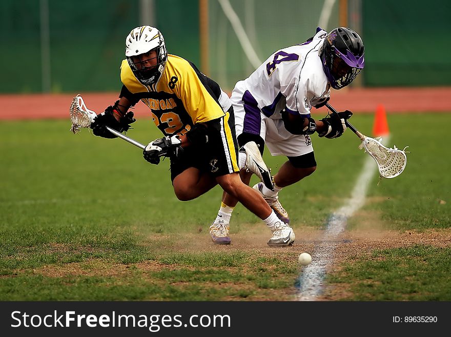 Man Wearing Yellow and Black Sport Jersey Holding Lacrosse Stick