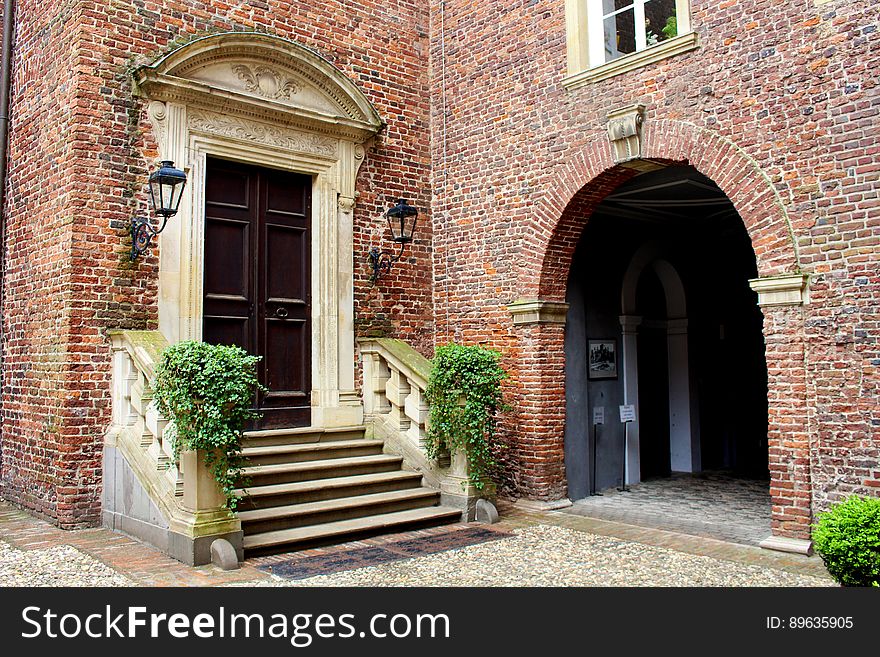 Stone stairs leading to wooden door outside brick building on sunny day. Stone stairs leading to wooden door outside brick building on sunny day.