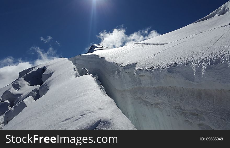 Crevasse in glacier ice on Ortler mountain in Alps, Italy against blue skies on sunny day. Crevasse in glacier ice on Ortler mountain in Alps, Italy against blue skies on sunny day.
