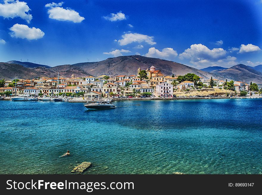 A view from the Greek archipelago with a city and blue sea. A view from the Greek archipelago with a city and blue sea.