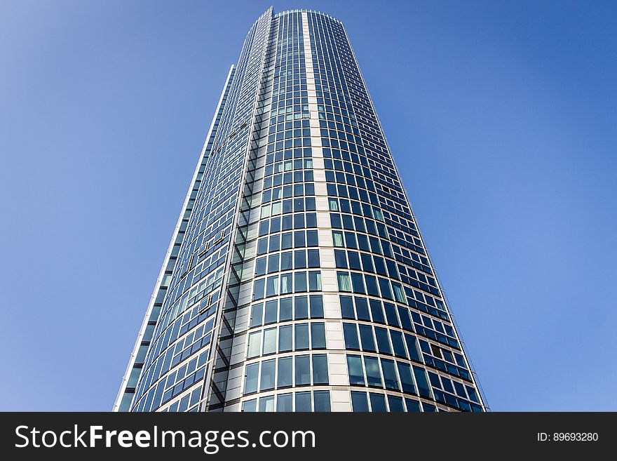 Facade of modern skyscraper against blue skies on sunny day.